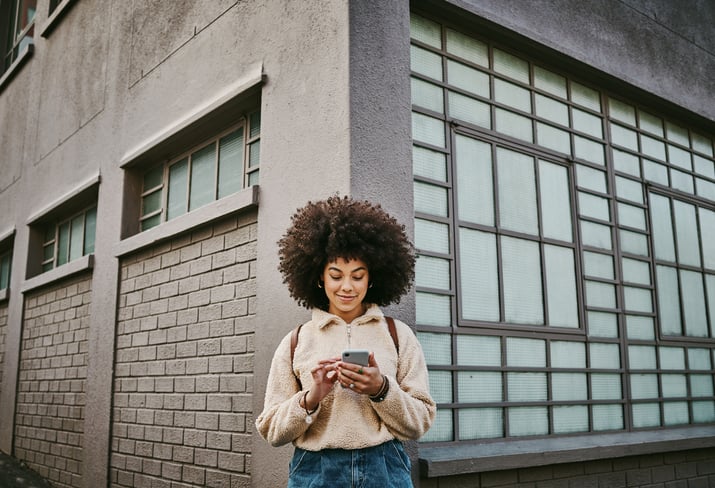 woman texting on phone outside