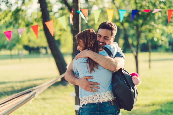 guy hugs woman outdoors