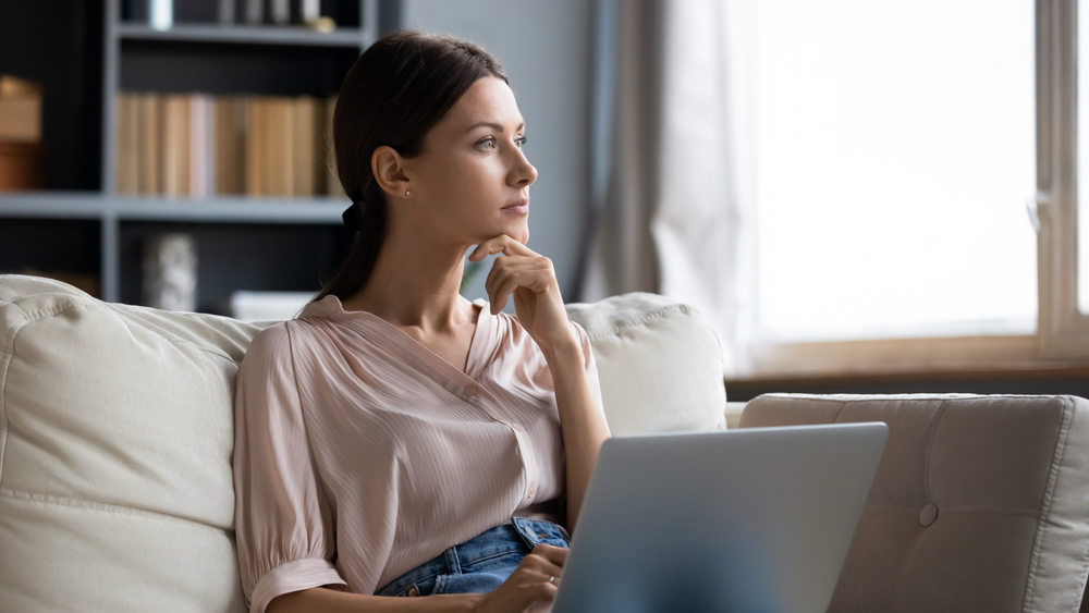 Distracted,From,Work,Worried,Young,Woman,Sitting,On,Couch,With