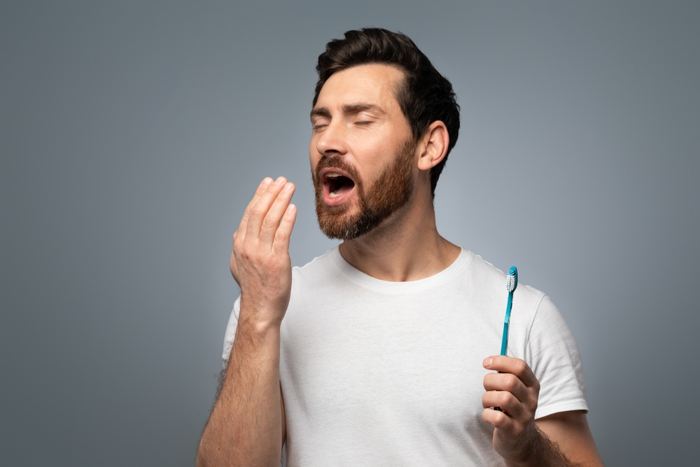 Middle,Aged,Man,Holding,Hand,Near,Mouth,And,Checking,Breath hygiene