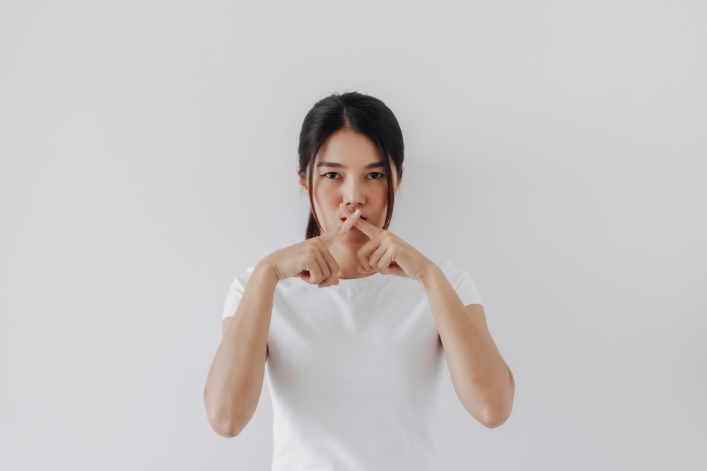 Asian,Thai,Woman,Hand,And,Fingers,Crossing,Cover,Mouth,,Keep