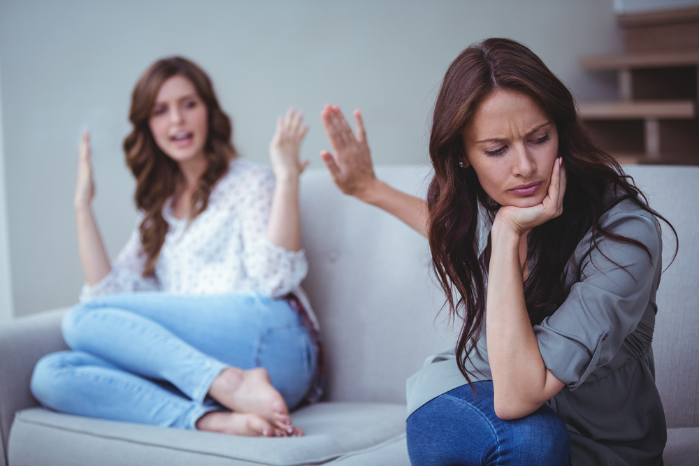 Two,Female,Friends,Sitting,On,Sofa,And,Arguing,With,Each